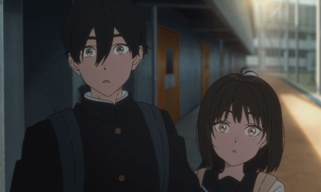 A boy and a girl in high school uniforms looking surprisedly into the camera